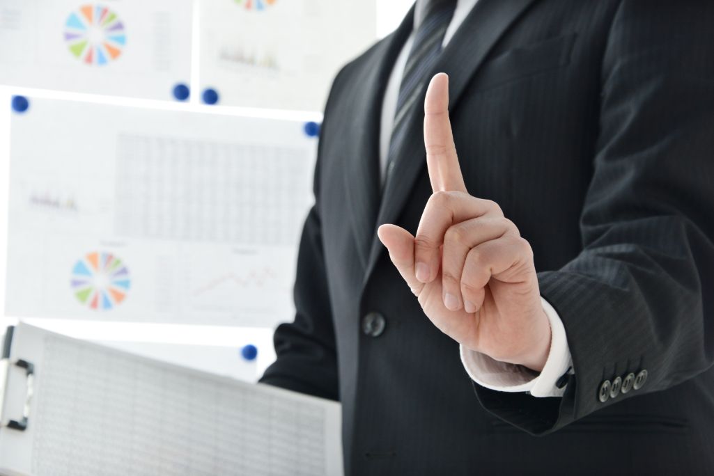指を立ててポイントを指し示すビジネスマン